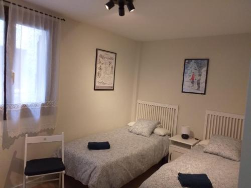 a bedroom with two beds and a window at Apartamento Casa Bielsa in El Pueyo de Jaca