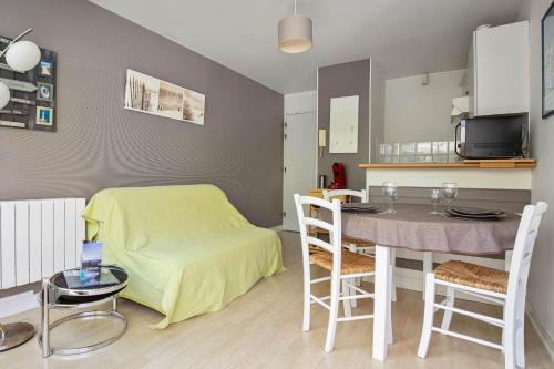 a living room with a dining room table and a kitchen at Nice flat with terrace near the city centre of La Rochelle - Welkeys in La Rochelle