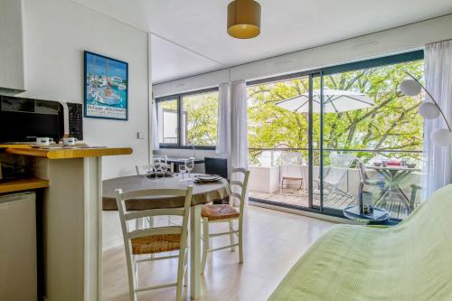 a kitchen and living room with a table and chairs at Nice flat with terrace near the city centre of La Rochelle - Welkeys in La Rochelle