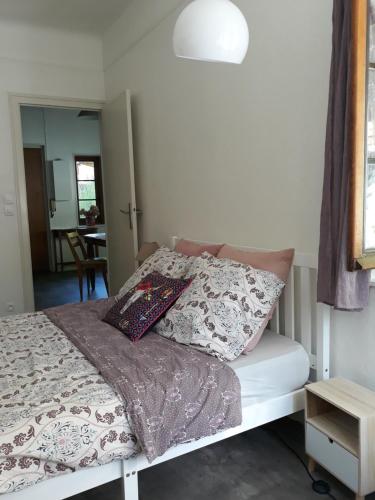 une chambre avec un lit avec des oreillers dessus dans l'établissement Appart-charme-Aix, à Aix-les-Bains