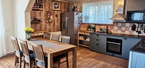 a kitchen with a wooden table and a refrigerator at HubaBuba in Ventspils