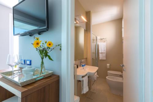 a bathroom with a sink and a tv on the wall at I Vereti in Patù