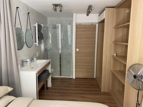 La salle de bains est pourvue d'une douche, d'un lavabo et d'un miroir. dans l'établissement Domaine des Restanques, suite parentale ,vue mer., à Grimaud