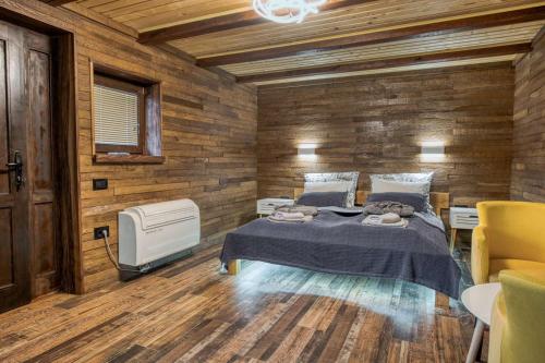 a bedroom with a bed and a wooden wall at Ribarski konaci in Doboj