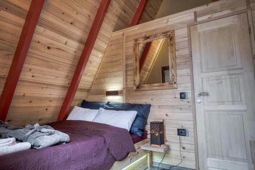 a bedroom with a bed in a wooden cabin at Ribarski konaci in Doboj