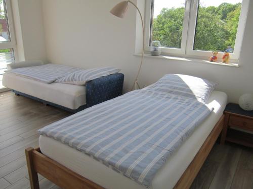 two beds in a room with two windows at Ferienwohnung de Jong in Sendenhorst
