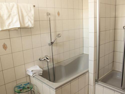 a bathroom with a tub and a shower with towels at Villa Seenland in Böhlen