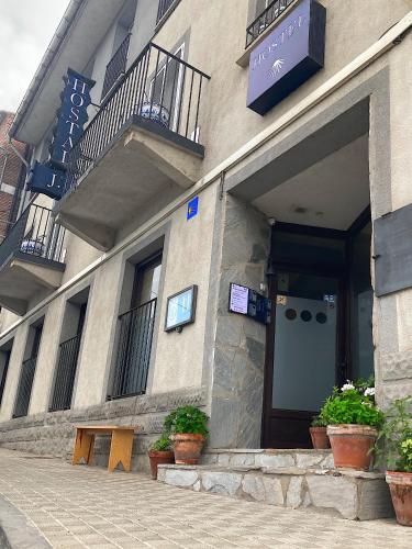 a building with potted plants in front of it at Hostal JP y Estudios in Sangüesa