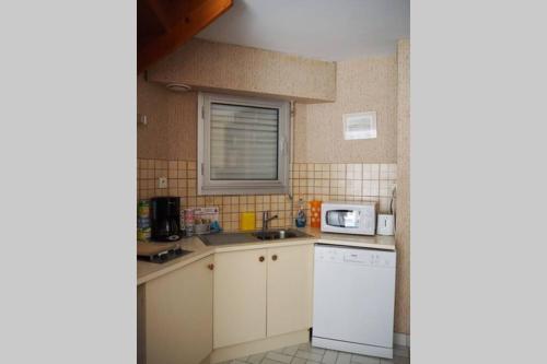 una pequeña cocina con electrodomésticos blancos y una ventana en MAISON T2 WIFI Parking Privé Les Sables d'Olonne 9mn à Pied Plage Présidents, en La Rudelière