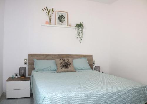 a bedroom with a bed with a blue comforter at Apartamento Eucaliptus B - Delta del Ebro in L'Eucaliptus