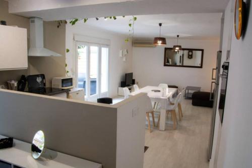 une cuisine et un salon avec une table et des chaises dans l'établissement La maison de Papé, à Arles