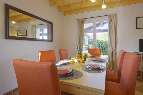- une table à manger avec des chaises orange et un miroir dans l'établissement La Maison du Marais - Welkeys, à Labenne