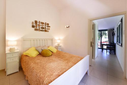 カダケスにあるPequeño y acogedor en el centro de CADAQUÉSのベッドルーム1室(大型ベッド1台、黄色い枕付)