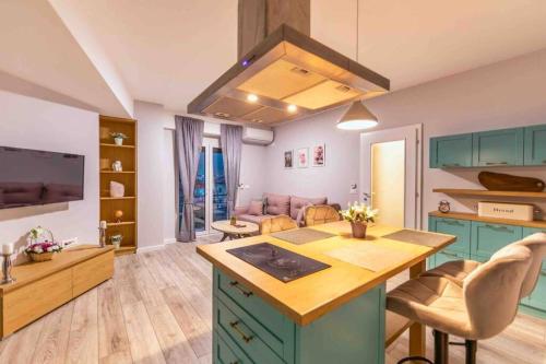 a kitchen with green cabinets and a living room at Apartment Dudanovski City Center - Apartment No. 4 in Ohrid