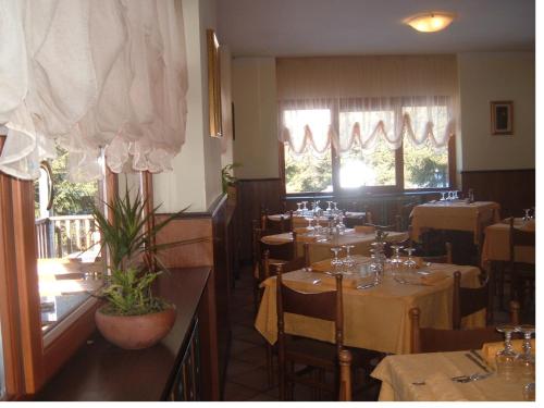 une salle à manger avec des tables et des chaises dans un restaurant dans l'établissement Albergo Pineta, à Gerola Alta