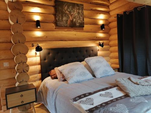 a bedroom with a bed in a log cabin at L'Edelweiss in Allos