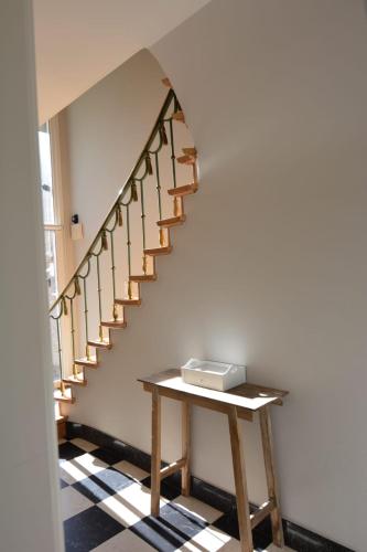 a stairway with a wooden table with a box on it at Villa O'Soleil in De Panne