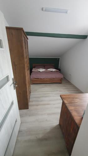 a attic room with a bed and a wooden door at Restauracja Domenico w Tylawie in Tylawa