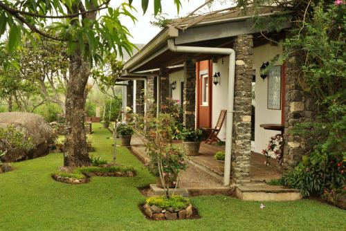 a stone house with a garden in front of it at Clouds Holiday Bungalow Haputhale in Haputale