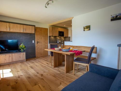 a kitchen and dining room with a wooden table and chairs at Ramslerhof - Chiemgau Karte in Inzell