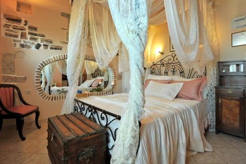 a bedroom with a canopy bed with a mirror at Archontiko Art Hotel in Galaxidhion