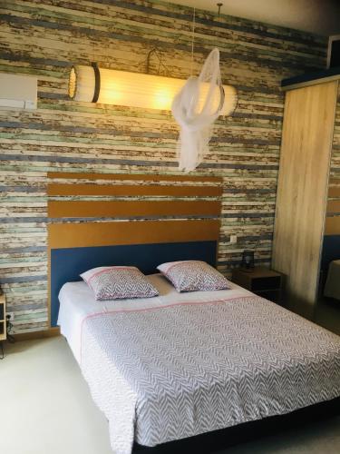 - une chambre avec un lit et un mur en bois dans l'établissement Casa Léon, à Narbonne