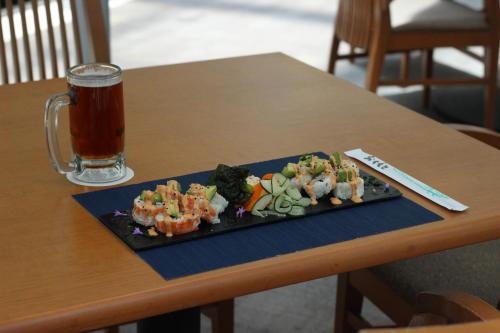 a plate of sushi and a glass of beer on a table at Crowne Plaza Leon by IHG in León