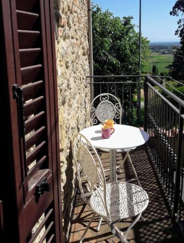 una mesa y sillas en el balcón de una casa en CasaLina appartamento a Casale Marittimo, en Casale Marittimo