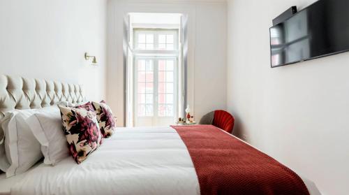 een slaapkamer met een wit bed en een rode deken bij LeL Madalena GuestHouse in Lissabon