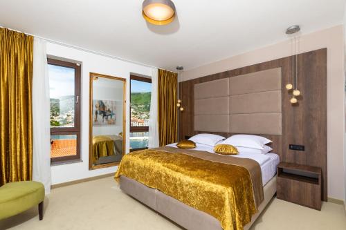 a bedroom with a large bed and a large window at Hotel Meduza in Senj