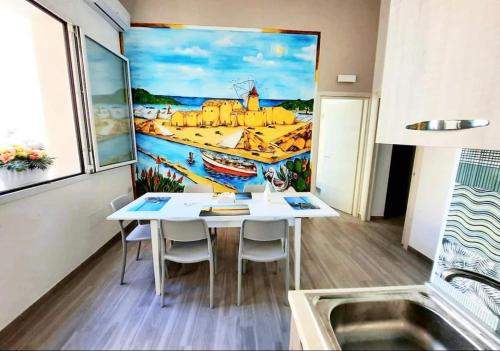 una sala da pranzo con tavolo e un dipinto sul muro di SoleMare Alloggio Turistico a Marsala