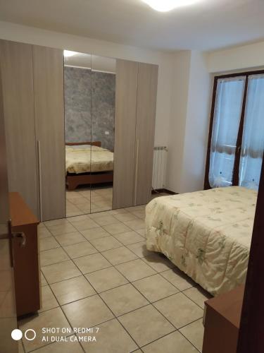 1 dormitorio con cama y espejo en Mamma Giulia, en Stroncone