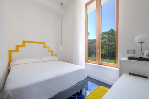 a white bedroom with a bed and a window at Hotel Nice in Sorrento