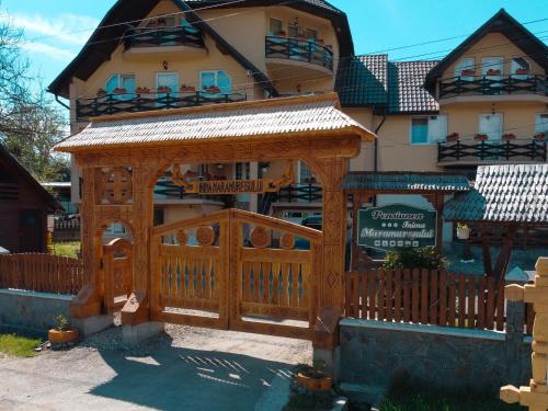 a wooden gazebo in front of a house at Pensiunea Inima Maramureșului in Breb