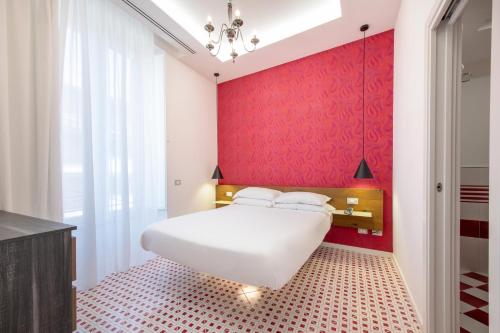 a bedroom with a white bed and a red wall at Hotel Nice in Sorrento