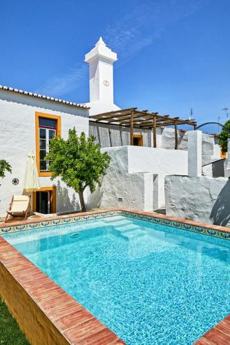 a swimming pool in front of a house at Casa de Veiros - Estremoz in Estremoz