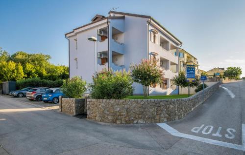 a building with a stone wall next to a street at Apartments Kvarner in Malinska