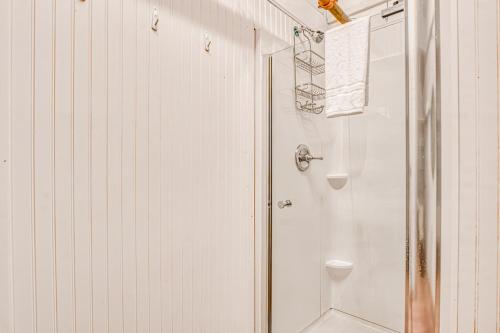 ein weißes Bad mit einer Dusche und einem WC in der Unterkunft Carbo House Eleven in Tybee Island