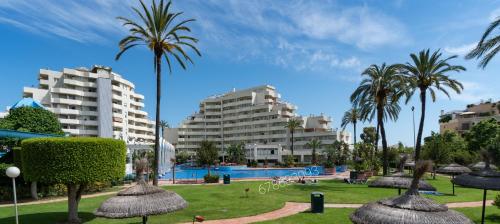 ośrodek z basenem, palmami i budynkami w obiekcie Benalbeach w mieście Benalmádena