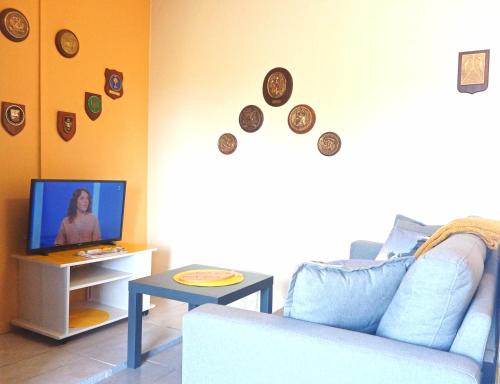 a living room with a couch and clocks on the wall at le Refuge d'Eugénie in Bahus-Soubiran