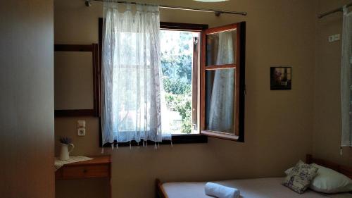 a bedroom with a window and a bed and a mirror at Zia with a view - Ζια με θεα in Lagoúdi Zía
