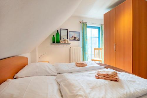 a bedroom with a large white bed with towels on it at Ferienpark Freesenbruch Doppelhaushälfte 11 - Windflüchter in Zingst