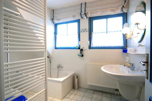 ein Badezimmer mit einem Waschbecken, einem WC und einer Badewanne in der Unterkunft Ferienpark Freesenbruch Doppelhaushälfte 12 - Sommerlust in Zingst