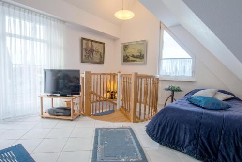 a bedroom with a bed and a flat screen tv at Appartementhaus Boddenblick "Himmelkieker" in Zingst