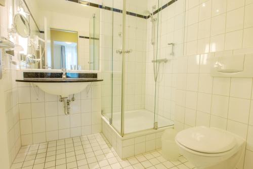 a bathroom with a shower and a toilet and a sink at Haus Seeblick Wohnung 326 in Zingst