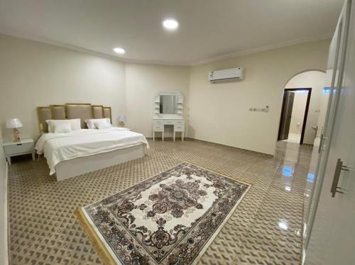 a bedroom with a bed and a rug on the floor at فيلا أمواج الشاطىء Amoaj beach in Rayyis