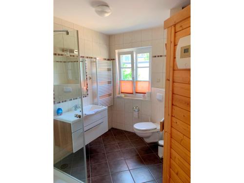 uma casa de banho com um WC, um chuveiro e um lavatório. em Haus Leni em Prerow