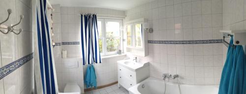 a bathroom with a tub and a sink and a toilet at Haus Zeesenboot Lee in Hiddensee