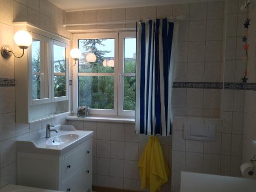 een badkamer met een wastafel en een raam bij Haus Zeesenboot Luv in Hiddensee
