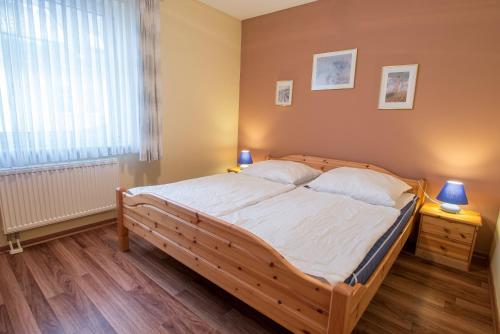 a bedroom with a large wooden bed with a window at Hoppenberg 9 EG links in Zingst